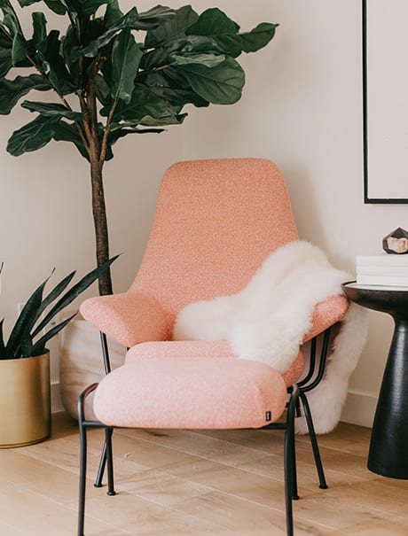 Pinkish chair with a tree background | California Closets