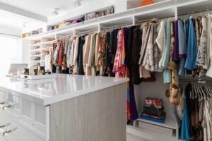 Custom walk-in closet with many coats | California Closets