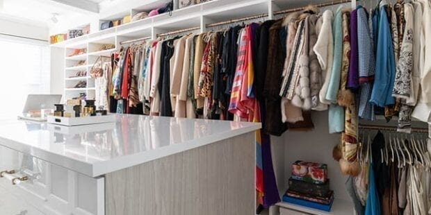 Custom walk-in closet with many coats | California Closets