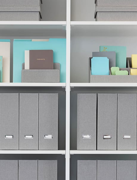 Custom closet with grey binders in storage compartments | California Closets