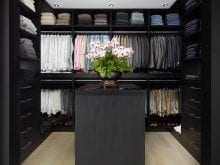 Custom black walk-in closet with wood flooring | California Closets