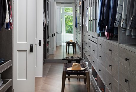 Custom walk-in closet with wall mirror and foot step | California Closets 