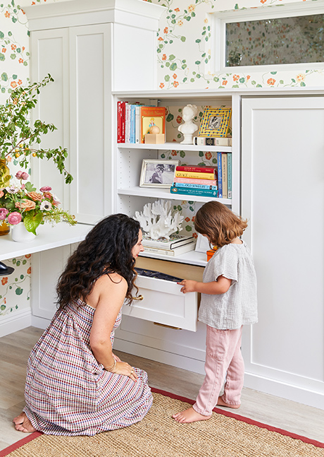 Custom white cabinet and lady with a kid opening drawer