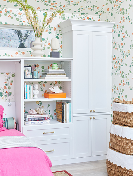 white four door cabinet and white shelves with books