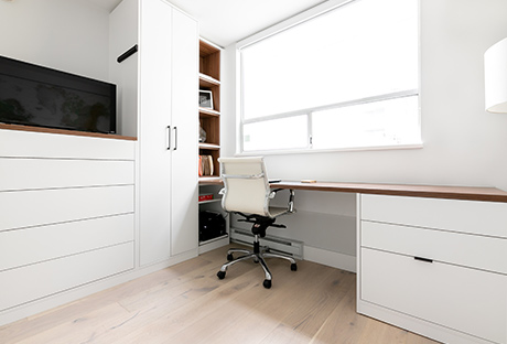 Custom home office with two door closet, office desk and chair with multiple storage spaces, featured in white