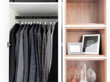 Custom closet with hanging rods for jackets, custom shelving and a custom dresser with displays