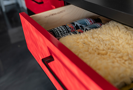 Custom red tool's drawer with black handle in garage storage space