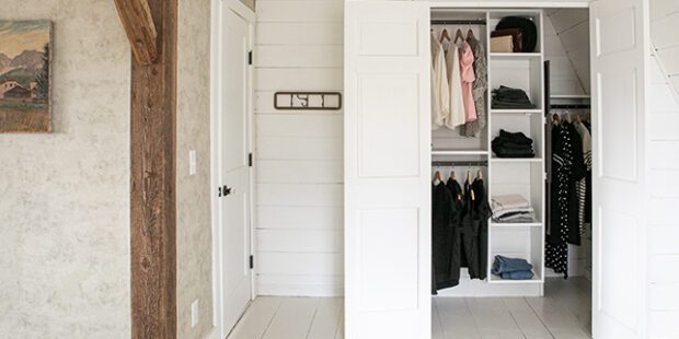 Custom white reach in closet with a shelving system and clothing rod