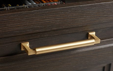 Wood grain finish with decorative hardware, shown in gold by California Closets
