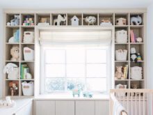 A baby’s crib in the custom home office with a custom shelving system designed by California Closets