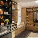 Custom LED lighting in a walk in closet in natural wood grain finish by California Closets