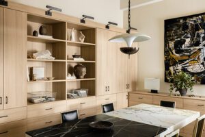 Interior designer, Jeremiah Brent’s custom office designed with cabinets, shelving and drawers in a light wood grain finish created by California Closets