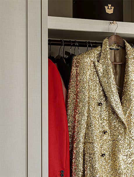 Una puerta de armario de California Closets se abrió para mostrar la chaqueta dorada personalizada de Jon Batiste.