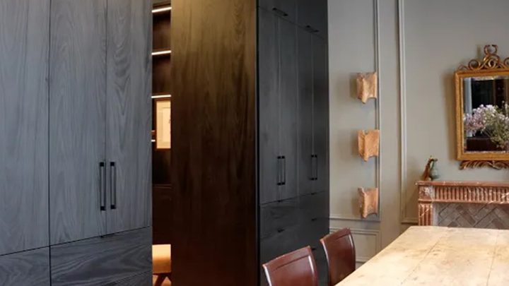 Oficina personalizada de Jeremiah Brent con acabado de madera oscura y herrajes metálicos de California Closets