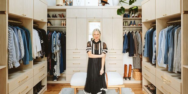 Walk in closet in high ceiling farmhouse space with custom cabinets, drawers and shoe storage by California Closets