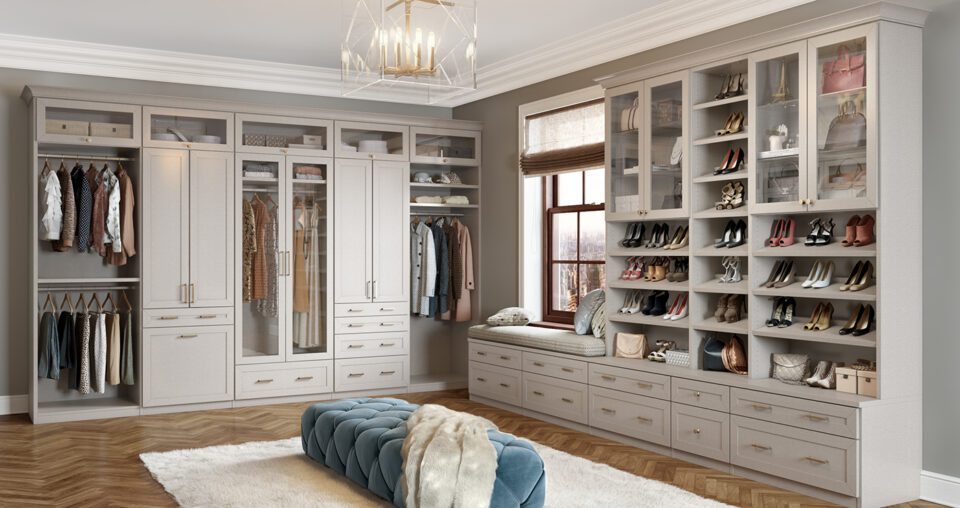 Vestidor diseñado con gabinetes, cajones y zapateros personalizados en un estilo boutique con acabado de madera clara por California Closets