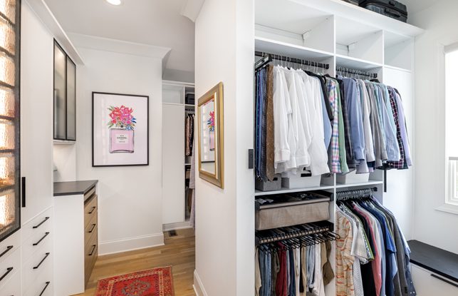 Su armario está diseñado con un acabado en madera veteada blanca con estantes personalizados y cajones creados por California Closets