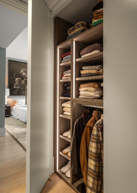Closet in the hallway used for folded sweaters, created in a light finish by California Closets
