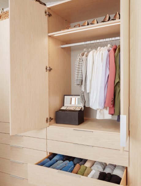 Guardarropa con puertas, gabinetes y cajones personalizados y almacenamiento para calzado creado por California Closets