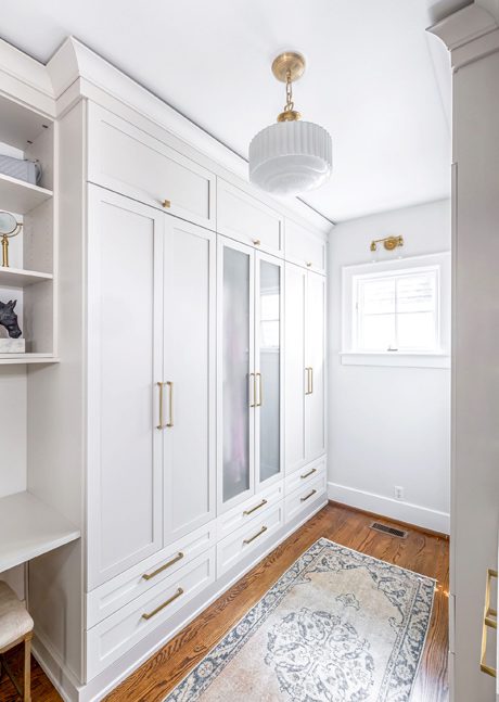 Diseño de armario en acabado de veta de madera clara con estantes empotrados para Candice King de California Closets