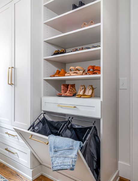 Pull out laundry cabinets in a walk in closet created for Candice King by California Closets