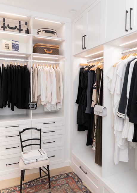Closet detail with built in drawers, cabinets, overhead storage and open shelves in white finish by California Closets