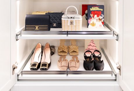 Shoe rack and shelf for purses in a walk in closet in white wood grain finish by California Closets