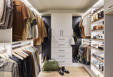 Netflix host Bobby Berk’s walk in cloffice with floor to ceiling custom cabinets for to hide office items created by California Closets