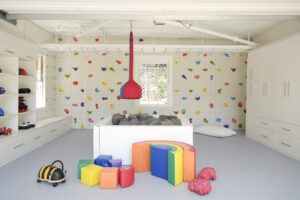Playroom space with storage after converting a Los Angeles garage for that incorporates a cushy floor, rock climbing wall and extra storage.