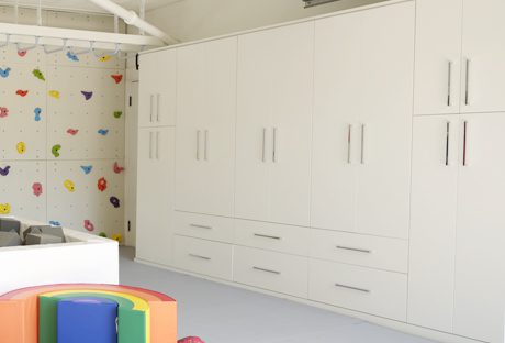 Garage storage cabinets created for an updated playroom space in white finish with metal hardware created by California Closets
