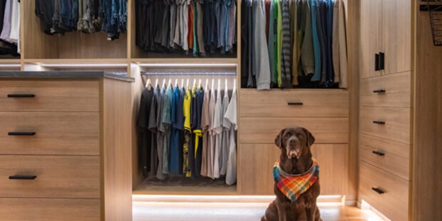 Walk-in closet custom storage LED lighting natural woodgrain finish, designed and created by California Closets