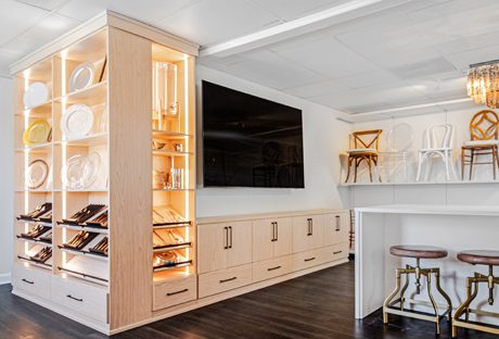 Corner storage shelving and cabinets in a natural finish design for a commercial showroom created by California Closets