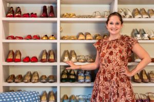 Shoe designer Sarah Flint's customized shoe shevles in a large walk in closet with a dressing/sitting area created by California Closets