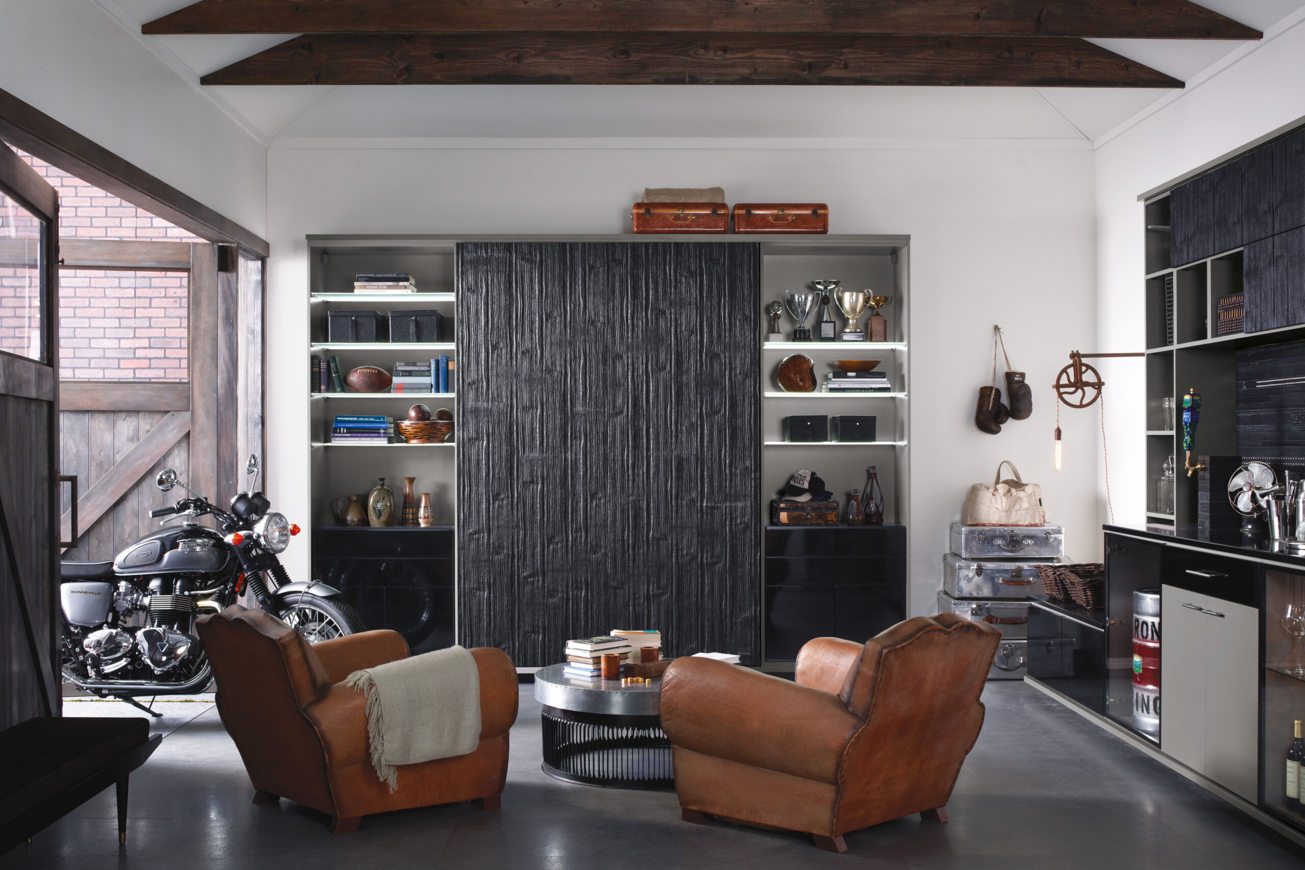 Garage repurposed to an entertainment center man cave space with custom storage, lighting and home bar by California Closets