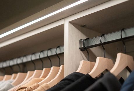 Racks de ropa de armario utilizando iluminación LED de cinta creada por California Closets