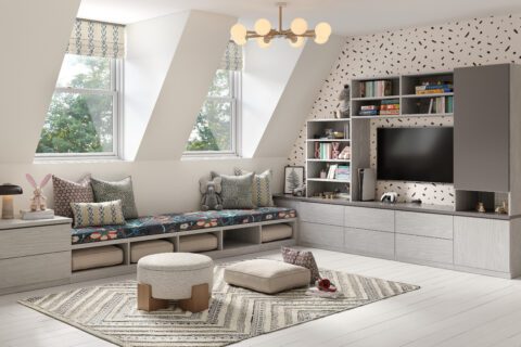Entertainment center wall in a custom playroom with custom drawers, storage cubbies and open shelves in wood grain finish by California Closets