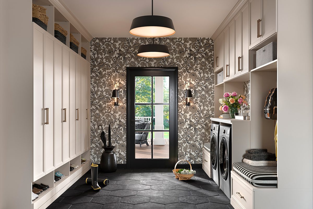 Mudroom designed with floor to ceiling storage cabinets, open shelving, bench with laundry room created by California Closets