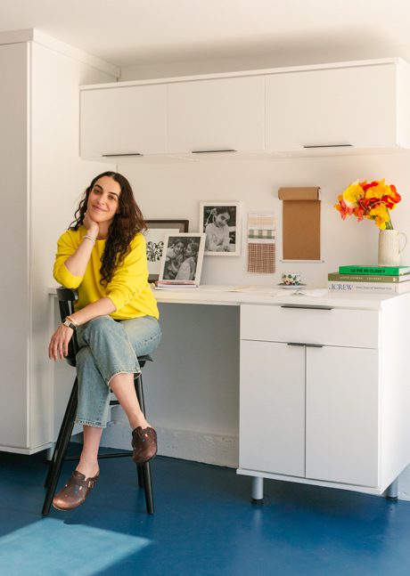 La diseñadora de Heather Taylor Home se sienta en su oficina en casa y espacio para manualidades recién diseñados con gabinetes de almacenamiento adicionales y escritorio incorporado creado por California Closets